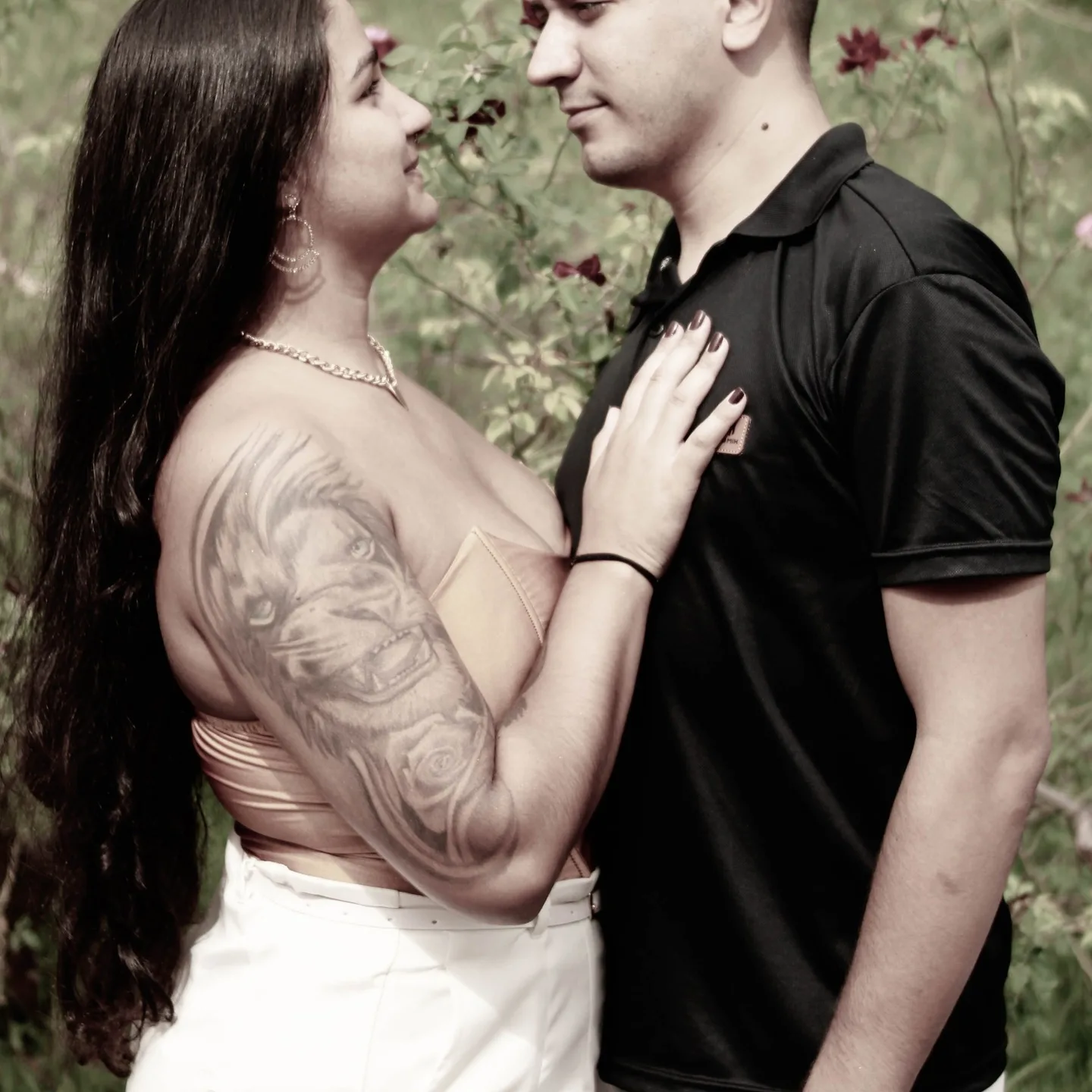 Casal se abraça em um jardim, em fotografia monocromática.